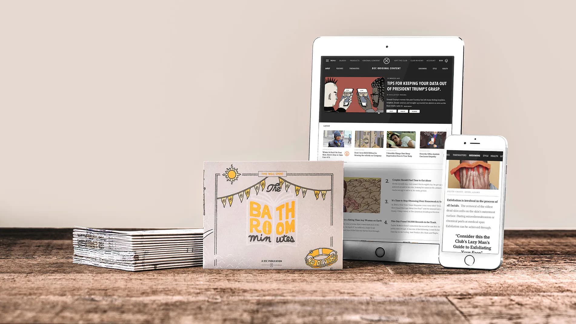 Dollar Shave Club Original Content on iPad and iPhone beside the printed Bathroom Minutes reader